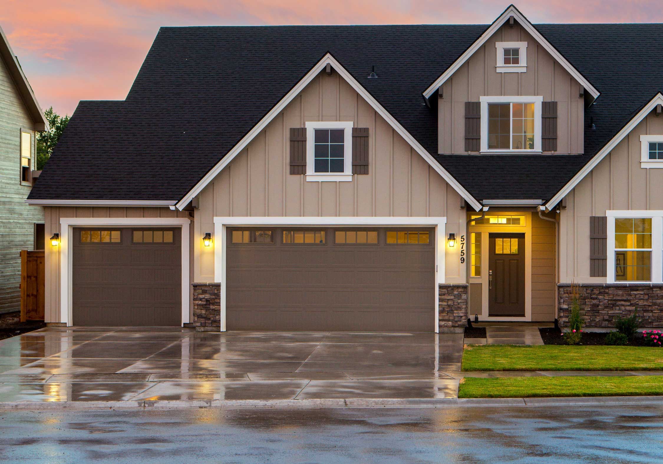 brown garage doors on a suburban home a dusk