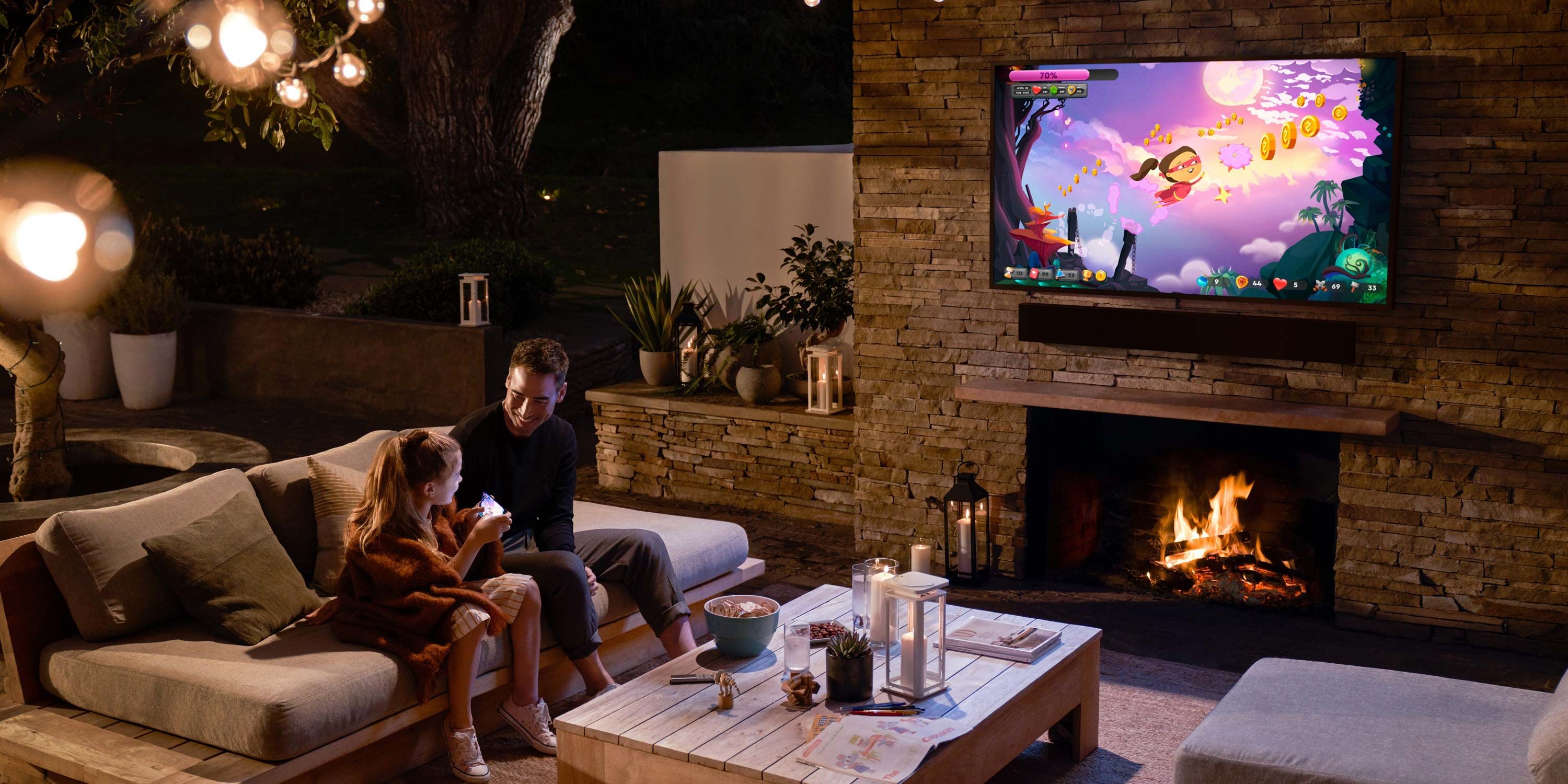 samsung tv and soundbar on a patio with a father and daughter