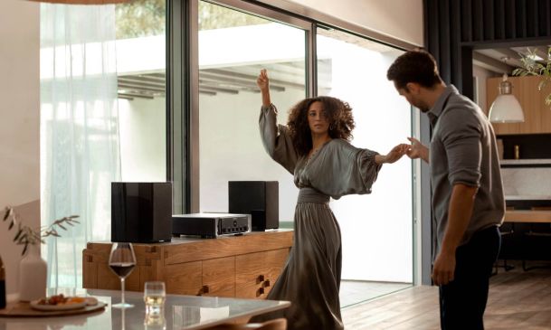 couple dancing to a marantz high performance audio sound system in a bright living area