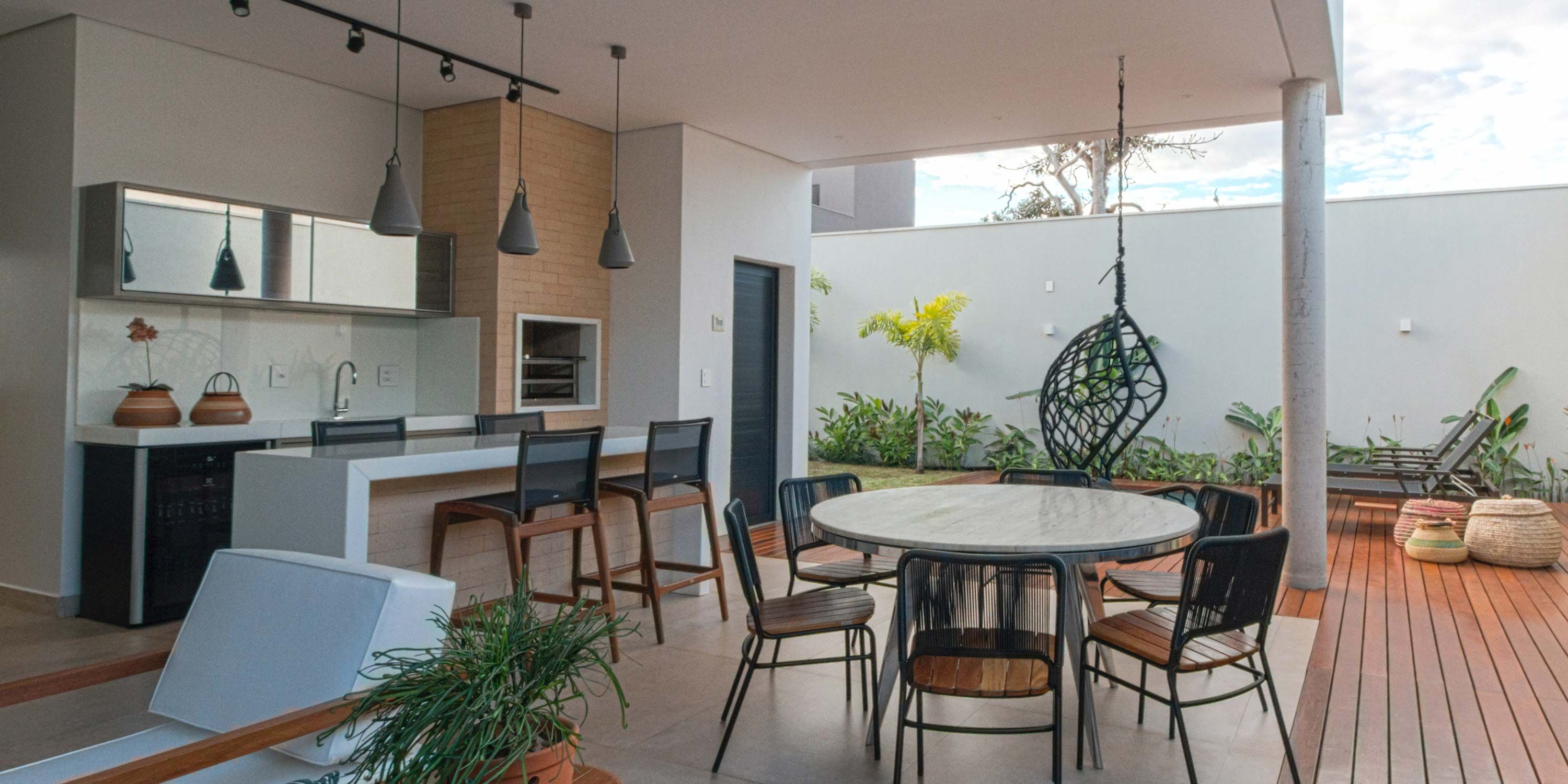 outdoor kitchen with black and wood chairs and modern lighting